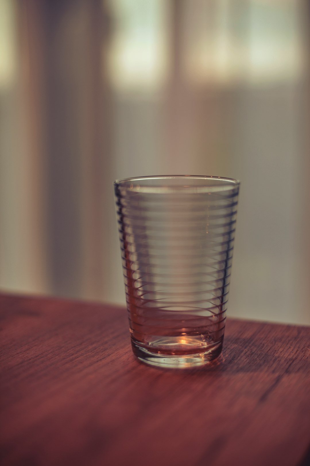 a glass sitting on top of a wooden table