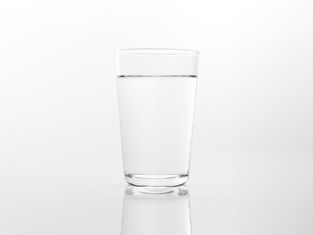 a glass of water on a reflective surface