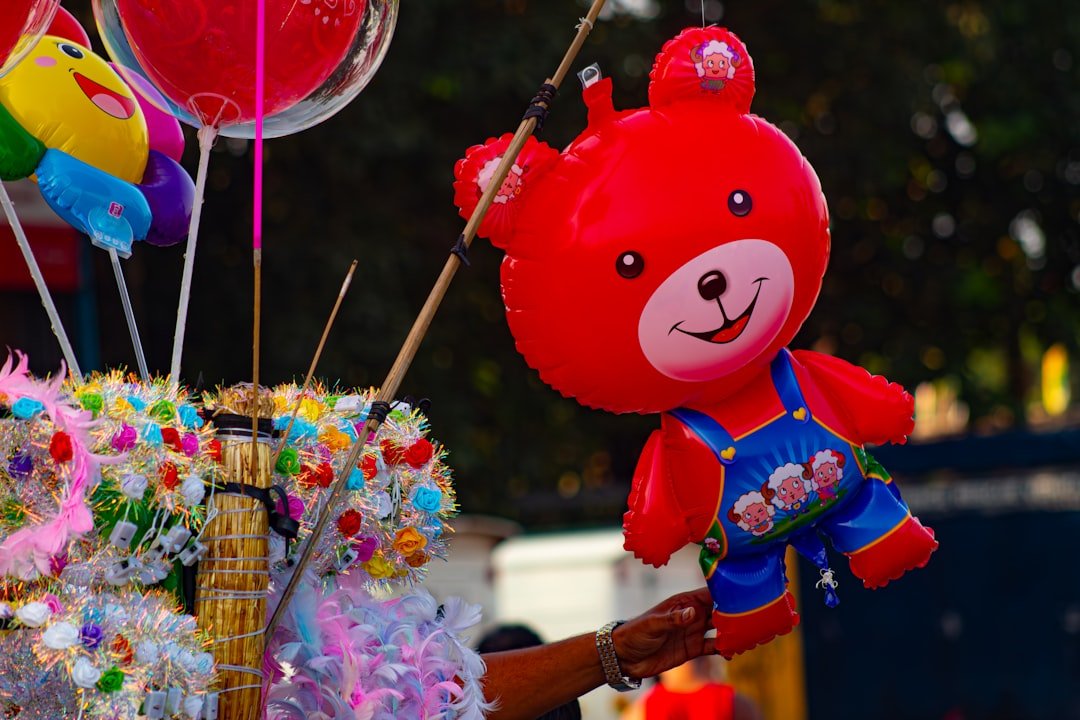 Red teddy bear balloon with other colorful balloons