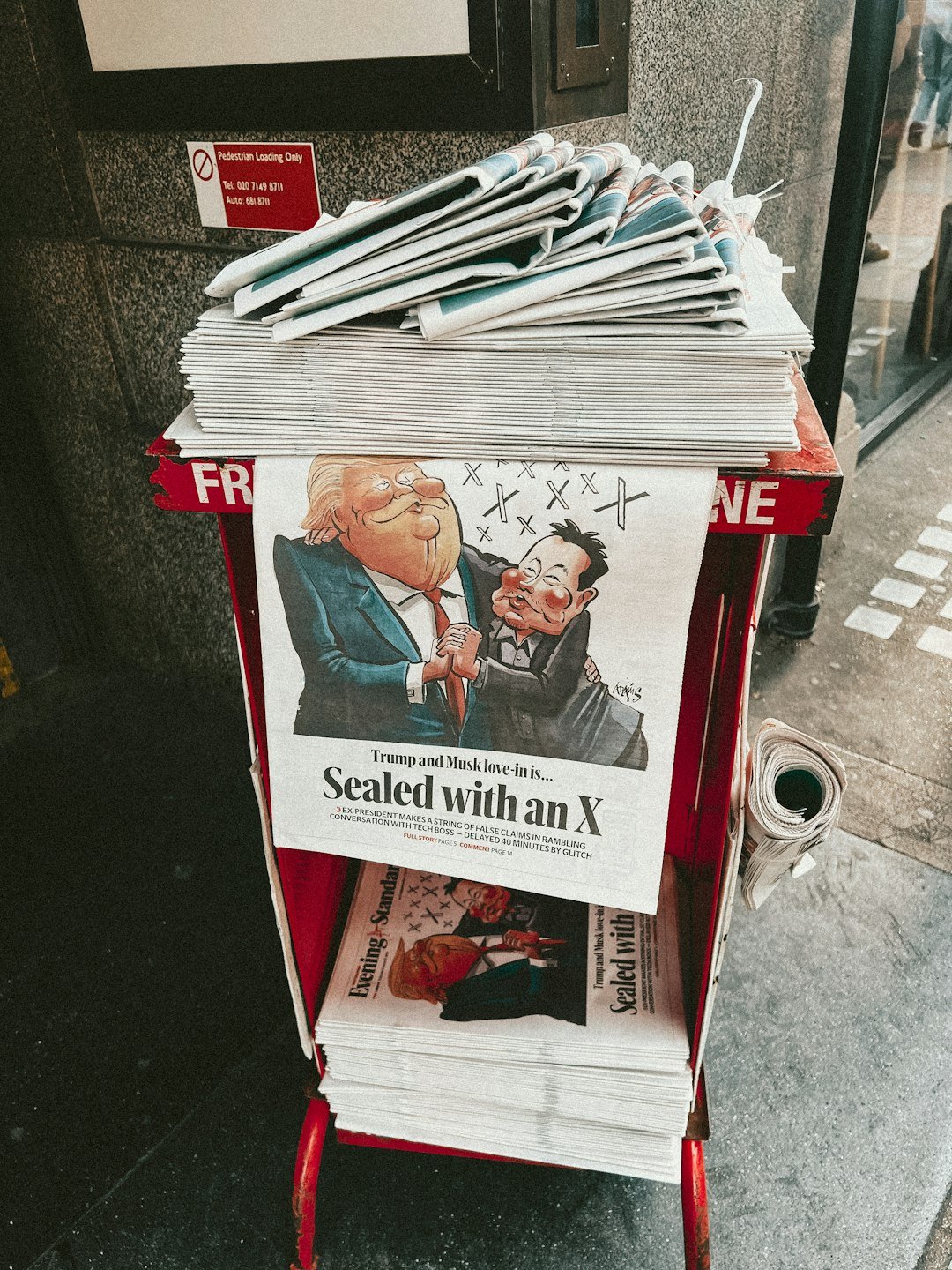 A newspaper stand with a bunch of newspapers on top of it