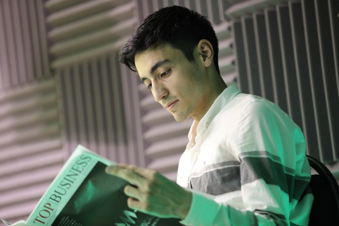 a man sitting down reading a book