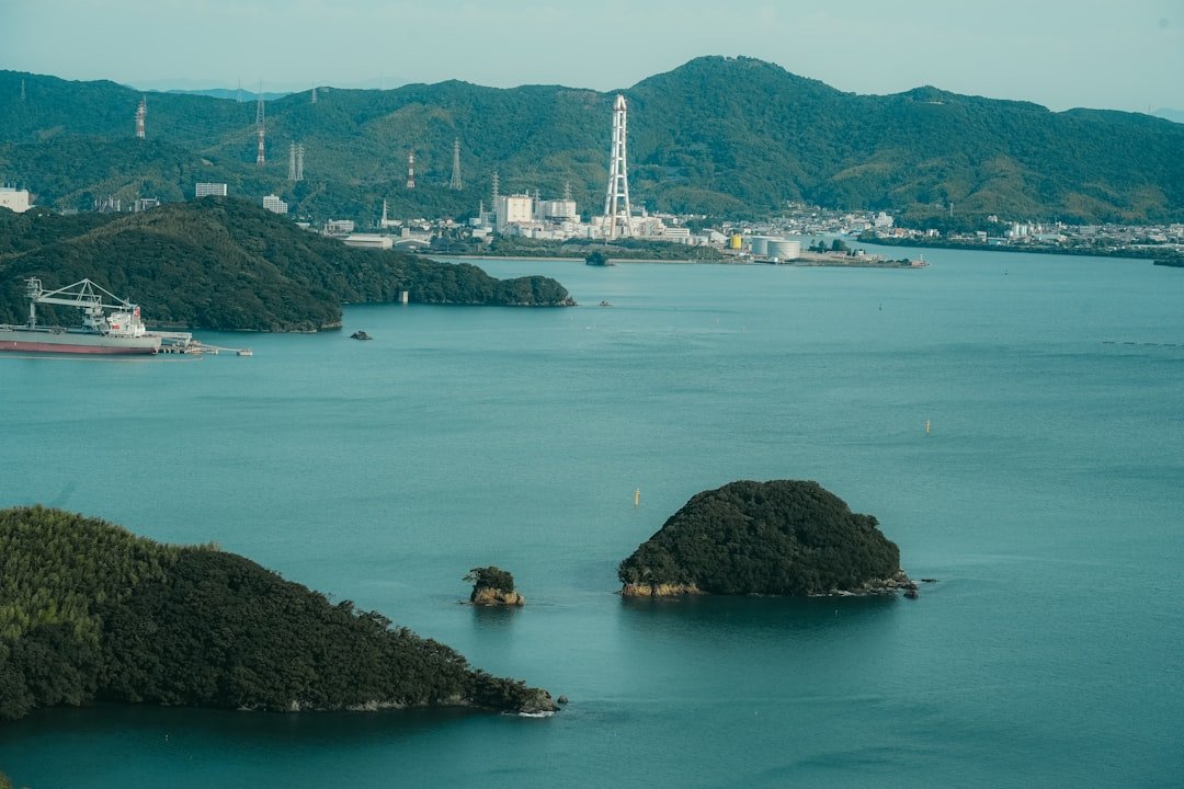 Coastal industrial complex with mountains and islands.