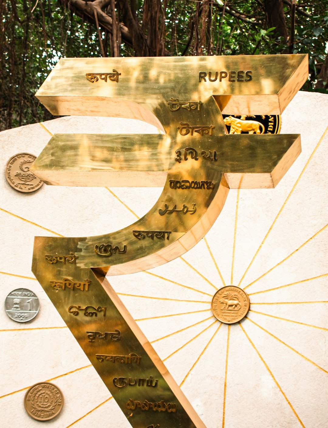A golden rupee symbol with indian currency details.