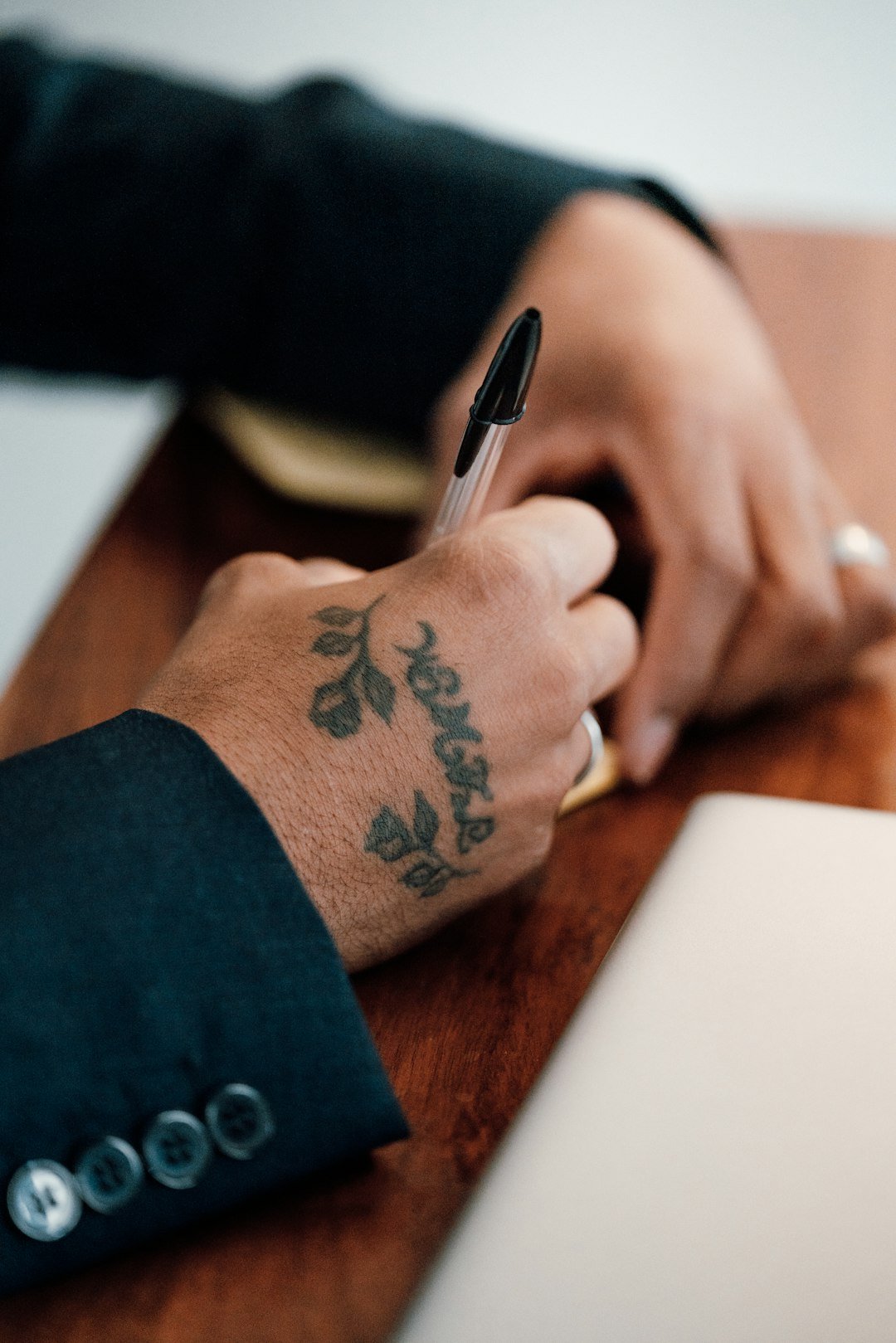 a person writing on a piece of paper with a pen