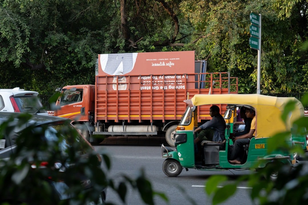 a green and yellow truck driving down a street