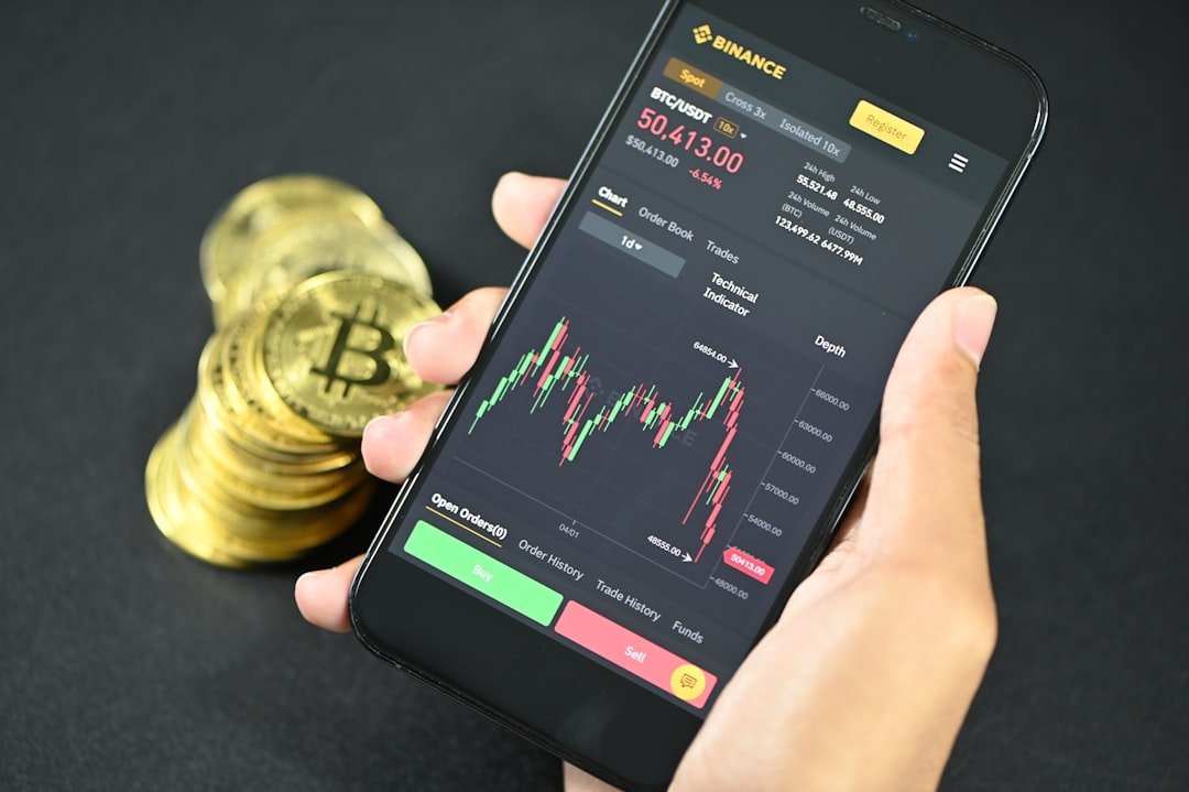 a person holding a phone with a bitcoin on the screen