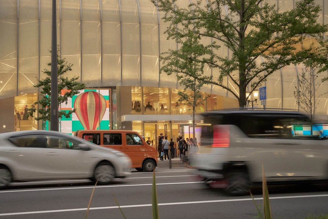 Cars passing by a modern building entrance