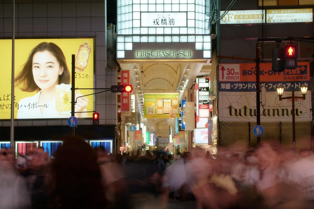 Crowded street with illuminated signs at night.