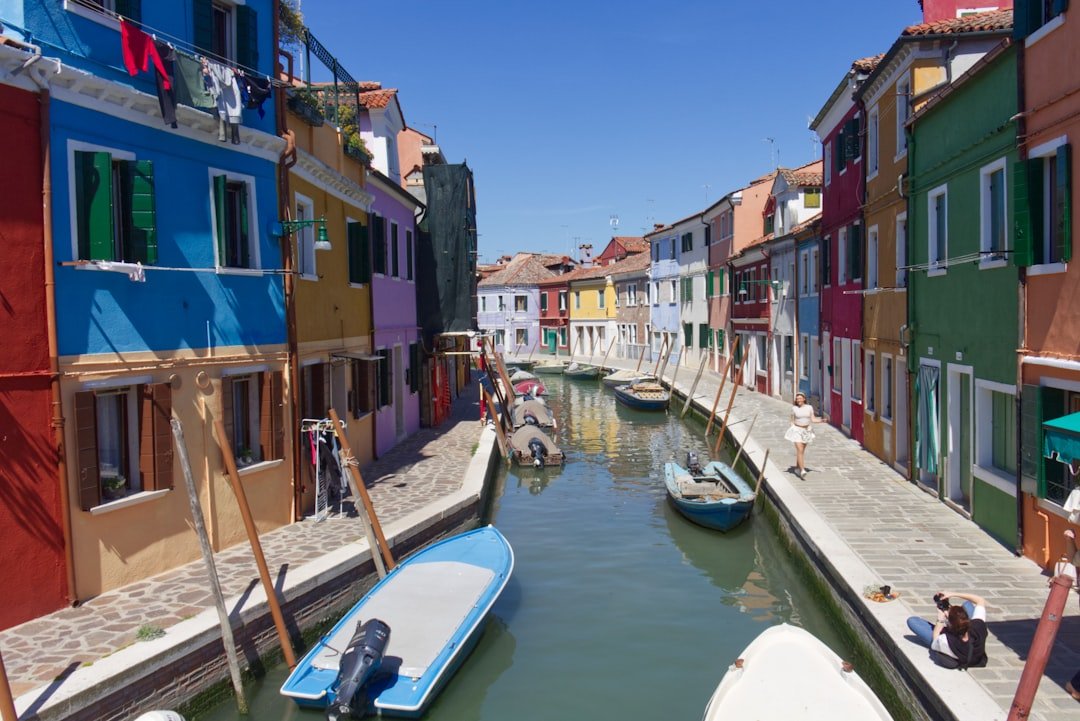 a canal filled with lots of boats next to tall buildings