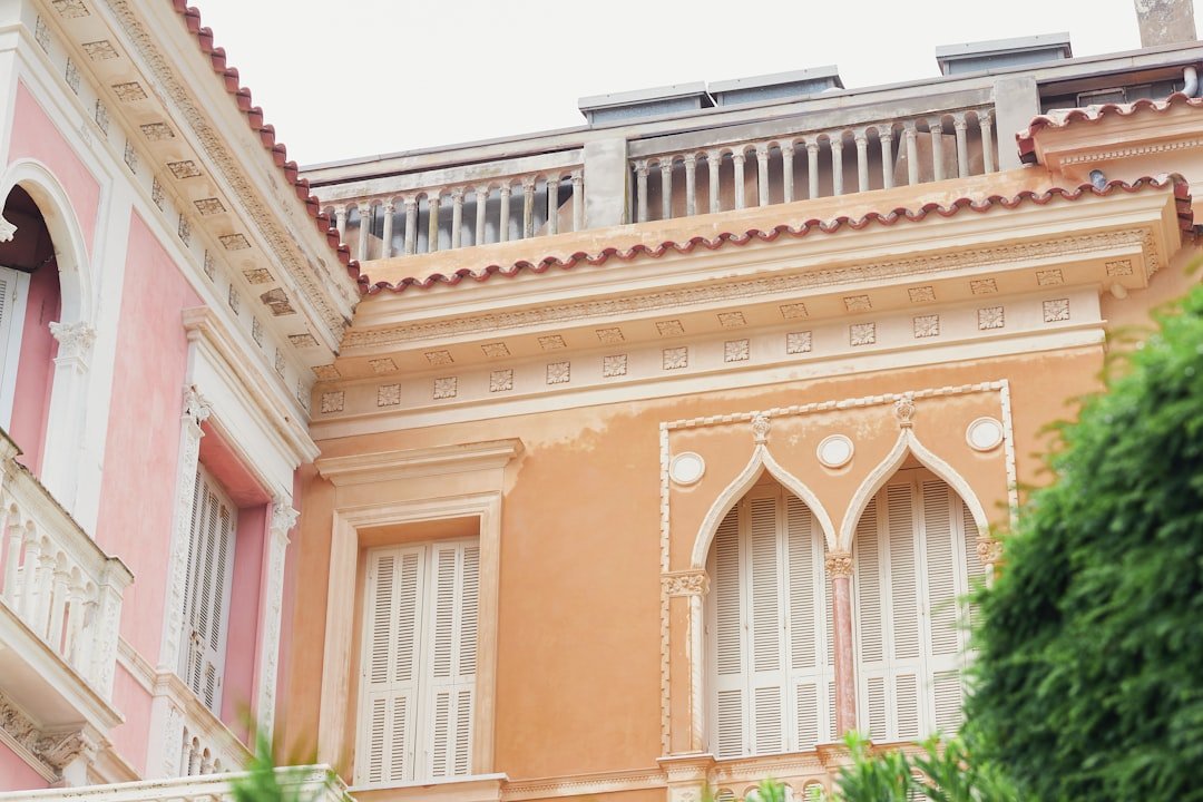 A pink and white building with a balcony