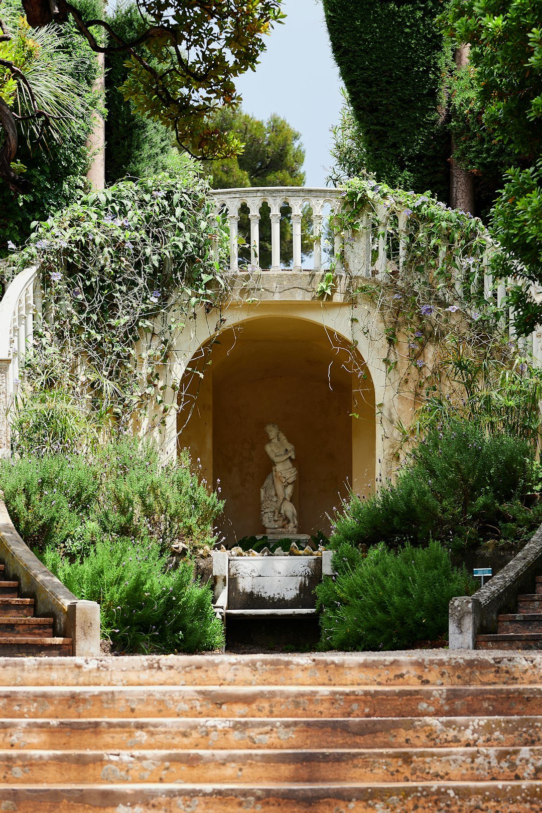 A staircase leading up to a statue in a garden