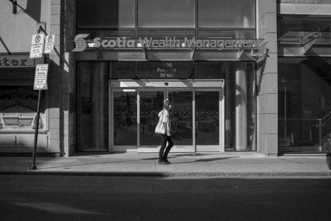 Woman walks in front of scotia wealth management entrance.